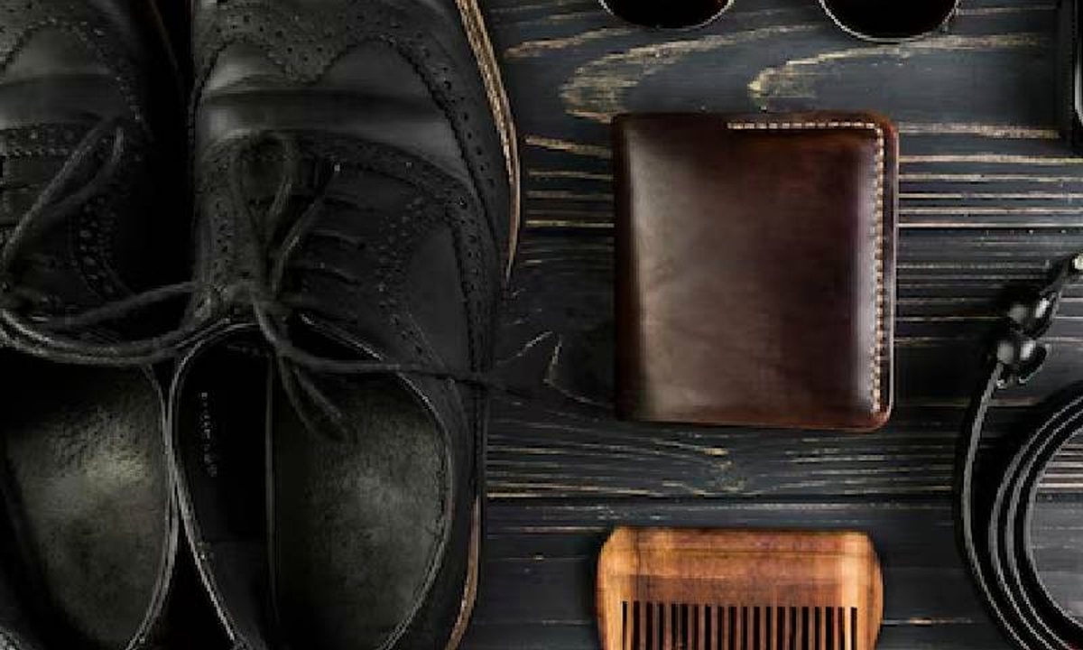 Sunglasses, shoes and accessories laid out on a dark surface